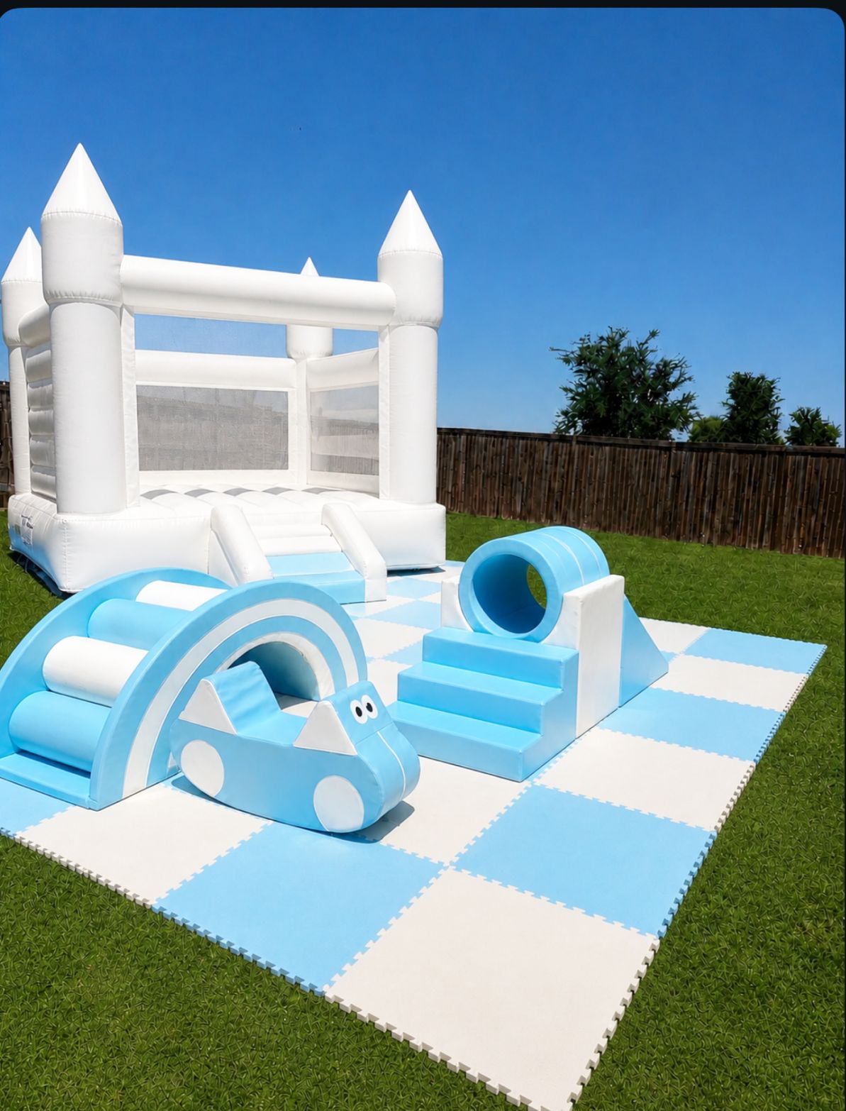 Blue soft play setup with a white bounce house and padded play pieces.